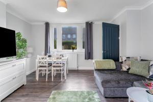 a living room with a couch and a table at Modern & Spacious 2 Bedroom House - Free Parking - Front & Back Garden - Private Main Door Entrance in Edinburgh