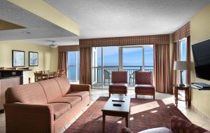 a living room with a couch and chairs and a television at Bay View Resort Myrtle Beach in Myrtle Beach