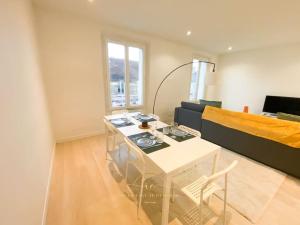 a living room with a table and a couch at Le Grand Rambolitain in Rambouillet