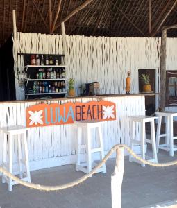 eine Bar mit einem Schild, das den Strand liest in der Unterkunft Luwa Beach&Suits in Watamu