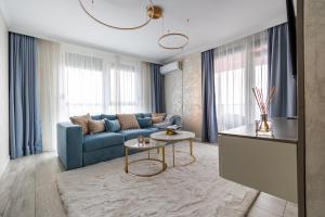 ein Wohnzimmer mit einem blauen Sofa und einem Tisch in der Unterkunft Arad Residence - DeLuxe Blue Apartment in Arad