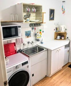una pequeña cocina con fregadero y lavadora en Kincumber Guest Suite en Kincumber