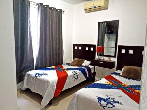 1 dormitorio con 2 camas y espejo en Departamento de dos habitaciones con increíble alberca y amenidades Y-406 en Cancún