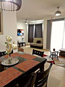 sala de estar con mesa de comedor y sala de estar con sofá en Departamento de dos habitaciones con increíble alberca y amenidades Y-406 en Cancún