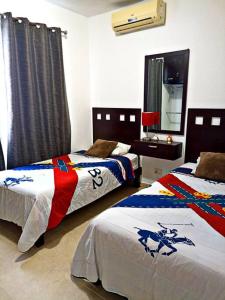 1 dormitorio con 2 camas y espejo en Departamento de dos habitaciones con increíble alberca y amenidades Y-406 en Cancún