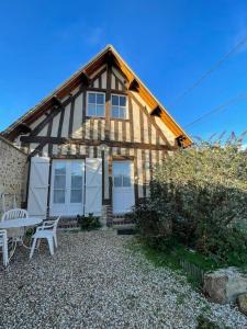 a house with a table and a bench in front of it at La Grange Chevrefeuille 