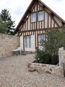 a house with a bench in front of it at La Grange Chevrefeuille 