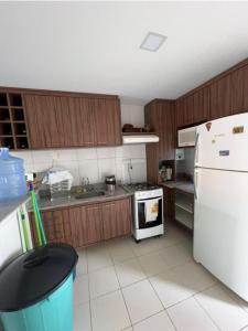 eine Küche mit Holzschränken und einem weißen Kühlschrank in der Unterkunft Villa Hípica Resort- Flat 203 in Gravatá + 4 Fotos