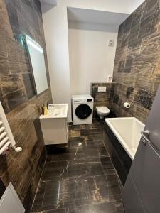 a bathroom with a sink and a toilet and a tub at Industrial Touch - designed in Iaşi