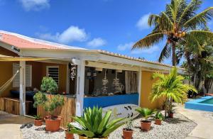 a house with a swimming pool and palm trees at Barefoot Bonaire in Kralendijk
