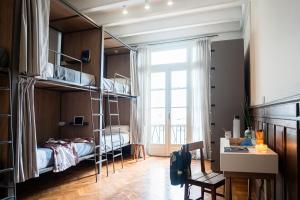 a bedroom with bunk beds and a desk and a window at Casa Franca Recoleta Hostel in Buenos Aires