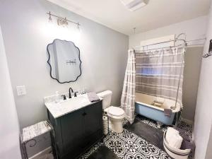 ein Badezimmer mit einem Waschbecken, einem WC und einer Badewanne in der Unterkunft Unwind & Relax at Azalea Cottage on Bayou in Lafayette