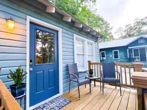a blue house with a deck with chairs and a door at Unwind & Relax at Azalea Cottage on Bayou in Lafayette