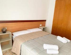1 dormitorio con 1 cama con 2 almohadas blancas en Apartamentos OlaMar, en Lloret de Mar