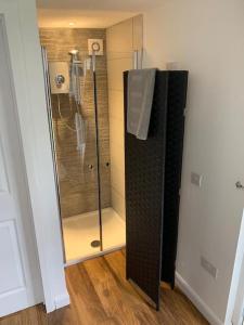 a shower with a glass door in a bathroom at The Old Beauty Room in Paulton +12 photos