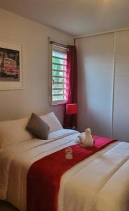 ein Schlafzimmer mit 2 Betten und ein Fenster mit einem ausgestopften Tier in der Unterkunft Le Petit Saint-Barth in Baie-Mahault