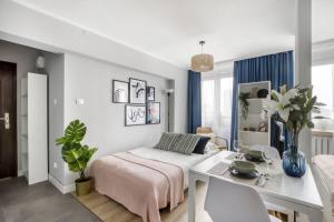 a bedroom with a bed and a dining room at Apartments Centre by Arrenda in Warsaw