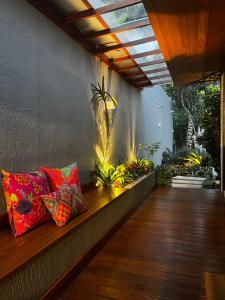 - une terrasse couverte avec 2 oreillers assises sur un banc en bois dans l'établissement Búzios House, à Búzios