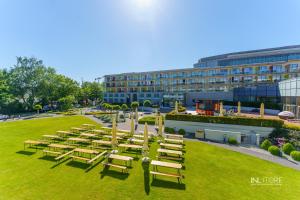 a row of tables and chairs in a park at 3L Apartments Aquarius in Kołobrzeg