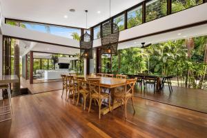 an open kitchen and dining room with a table and chairs at Pavilion 5 in Byron Bay