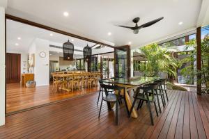 an open dining room with a glass table and chairs at Pavilion 5 in Byron Bay