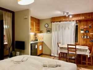 um quarto com uma cama e uma cozinha com uma mesa em Charmant Studio, 2 adultes , Centre de Nendaz em Nendaz
