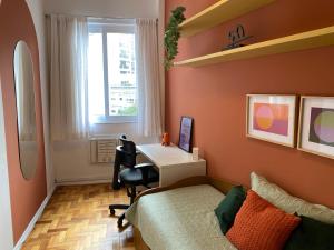 1 dormitorio con cama, escritorio y ventana en Baixo Leblon com charme, lazer e home office, en Río de Janeiro