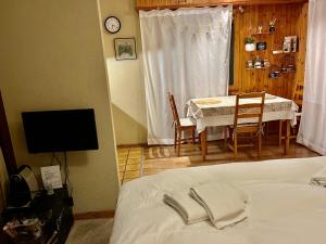 a bedroom with a bed and a table and a television at Charmant Studio, 2 adultes , Centre de Nendaz in Nendaz