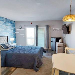 ein Schlafzimmer mit einem Bett und einem Tisch darin in der Unterkunft Luxury Suite in the Heart of Hamptons South Beach! in Hampton
