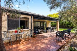 a deck with chairs and tables on a house at Surfside Getaway in Picturesque Inverloch in Inverloch