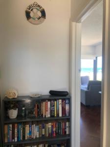 a book shelf filled with books in a living room at The Somerton Beach Retreat in Somerton Park