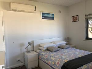 a bedroom with a bed and a air conditioner at The Somerton Beach Retreat in Somerton Park