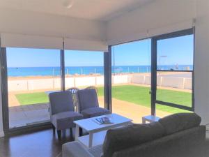 a living room with a view of the ocean at The Somerton Beach Retreat in Somerton Park