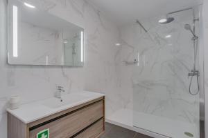 a white bathroom with a sink and a shower at Villa Winter APT 1 in Funchal +8 photos