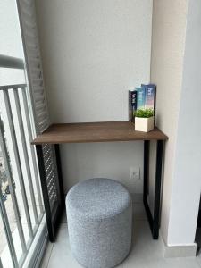 a shelf in a stair room with a stool and books at O melhor da studio da região! in Sao Paulo