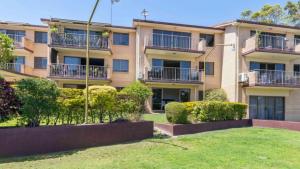 an apartment building with bushes in front of it at SeascapeatAlexBeach Budget Accomodation in Alexandra Headland