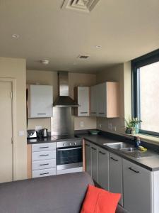 a kitchen with white cabinets and a stove top oven at Canal View 1 Bed Apartment in Zone 1 in London