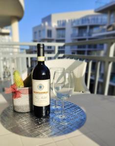 a bottle of wine and a glass on a table at Your Room, Your Apartment, Your Shared Pool in Marsalforn