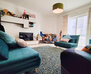 un soggiorno con 2 divani blu e una TV di Fur, Purr & Pool a Marsalforn