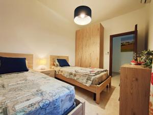 a bedroom with two beds and a mirror at Your Room, Your Apartment, Your Shared Pool in Marsalforn +26 photos