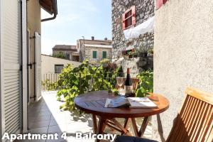 a wooden table on a balcony with a bottle of wine at Art Apartments Vrsar in Vrsar