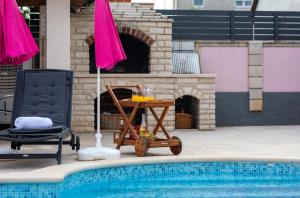 a table and two chairs next to a swimming pool at Vila Ana Apartman 1 in Fažana