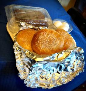 una comida de hamburguesas y bollos en papel de aluminio en Cabañas Esmeralda con Desayuno, en Punta Arenas