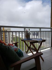 einen Tisch mit zwei Weingläsern auf dem Balkon in der Unterkunft Apto beira-mar pé na areia in Barra Velha
