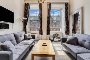 a living room with couches and a coffee table at Unique 2 Bedroom Castle Suite Apartment - Near Edinburgh Castle & Royal Mile in Edinburgh