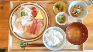 a wooden table with a plate of food and rice at irodori in Matsumoto