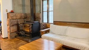 a living room with a couch and a fireplace at irodori in Matsumoto
