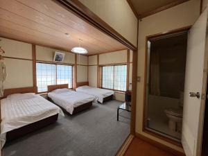 松本市にある乗鞍高原の宿　ｉｒｏｄｏｒｉのベッド2台と窓が備わる客室です。