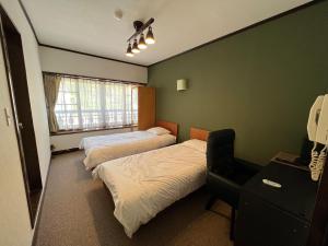 a bedroom with two beds and a chair in it at irodori in Matsumoto