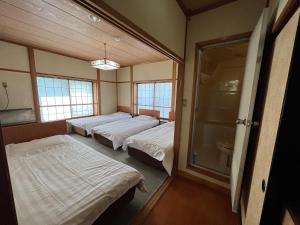a room with three beds and a window at irodori in Matsumoto